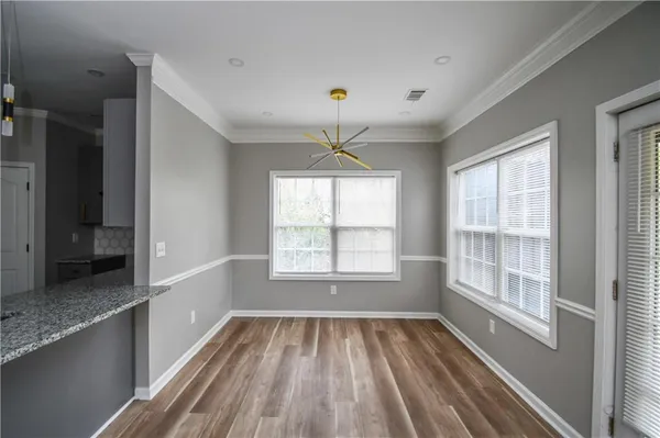 a view of an empty room with a window and wooden floor
