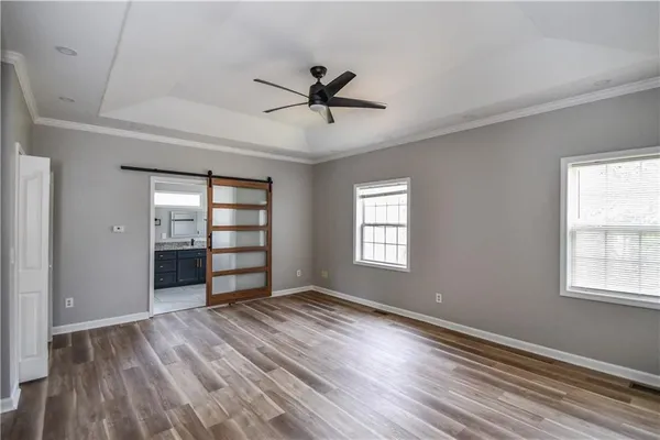 a view of a big room with wooden floor and windows