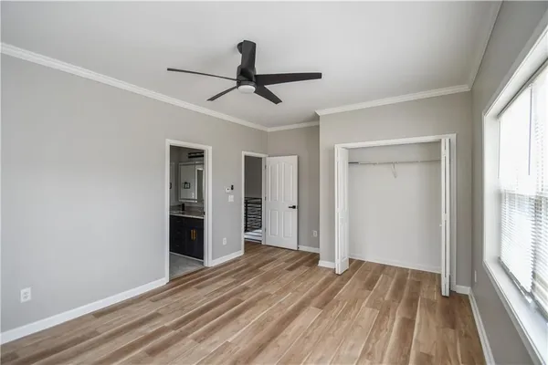 a view of empty room with wooden floor and fan