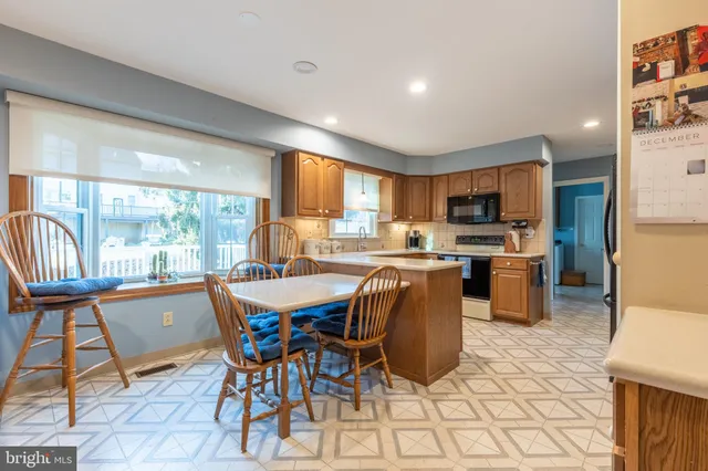 a view of a dining room with furniture a kitchen and chandelier