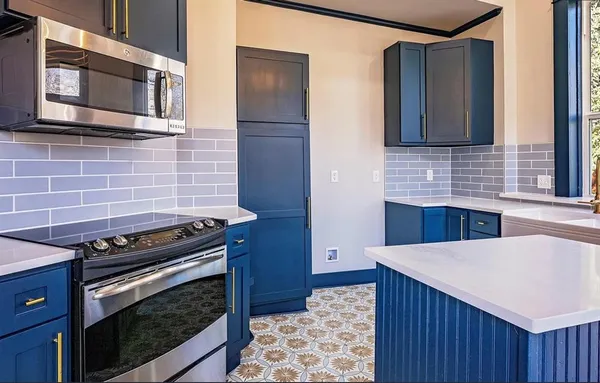 a kitchen with stainless steel appliances a stove a microwave and a sink