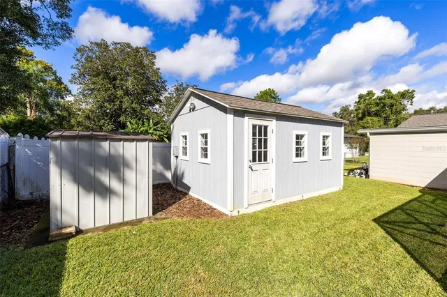 a view of a house with backyard and a tree