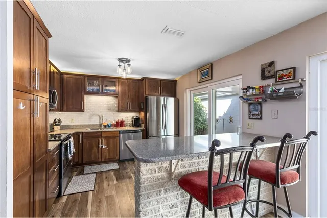 a kitchen with refrigerator and chairs