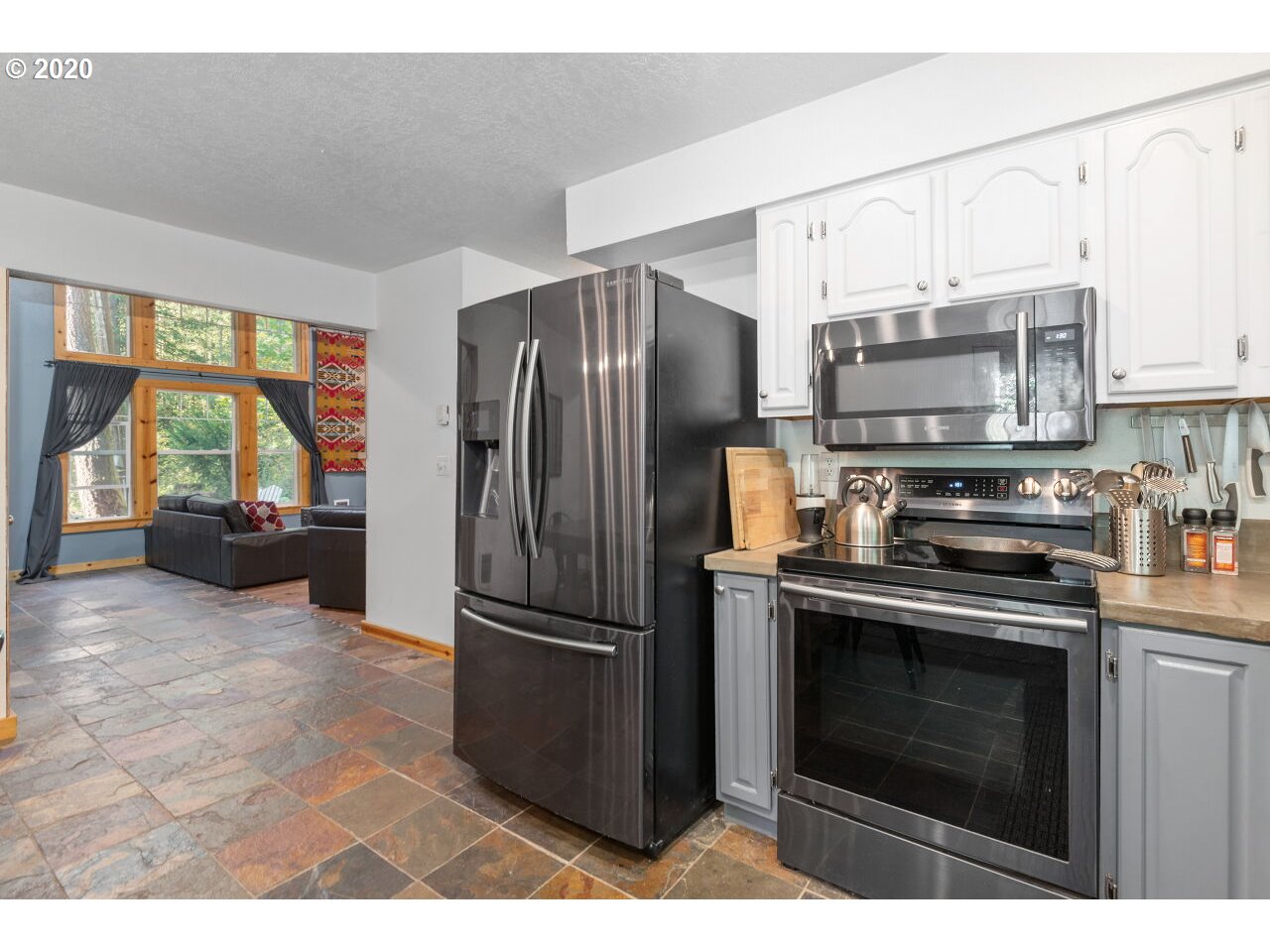 27780 East John Lake Road Rhododendron, OR 97049 - Photo 11 of 32 a kitchen with stainless steel appliances granite countertop a stove a refrigerator and a sink