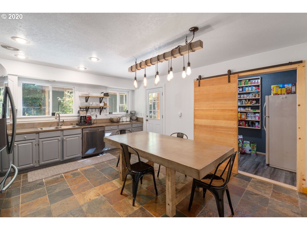 27780 East John Lake Road Rhododendron, OR 97049 - Photo 14 of 32 a open dining room with stainless steel appliances kitchen island a table chairs and a refrigerator