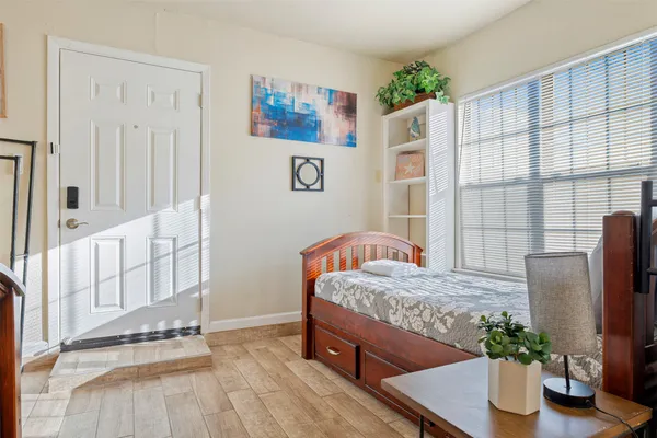 a view of a hallway with wooden floor and a bedroom