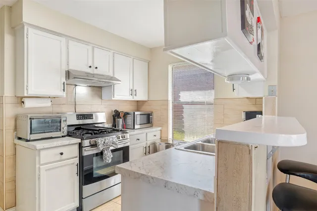 a kitchen with a sink stove and cabinets