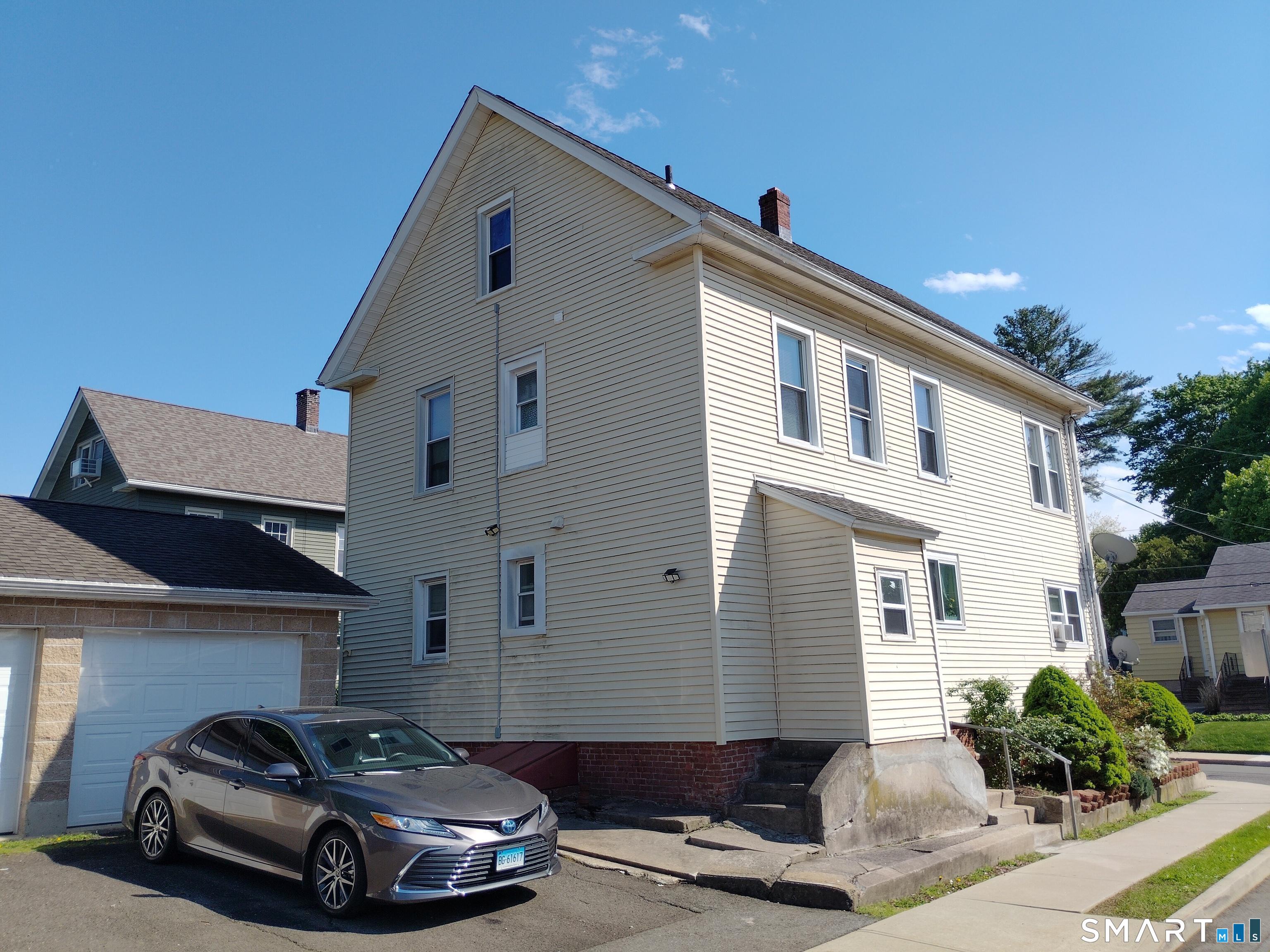 61 Bartlett Street Meriden, CT 06451 - Photo 3 of 30 a car parked in front of a white house