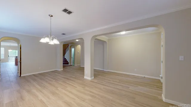 a view of a room with wooden floor chandelier and closet