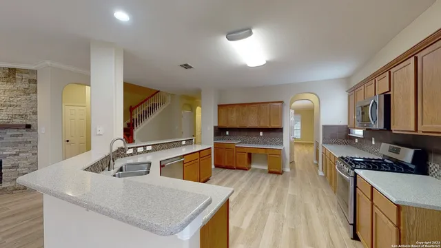 a kitchen with stainless steel appliances granite countertop a sink stove and refrigerator