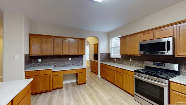 a kitchen with stainless steel appliances granite countertop a stove a sink and a microwave