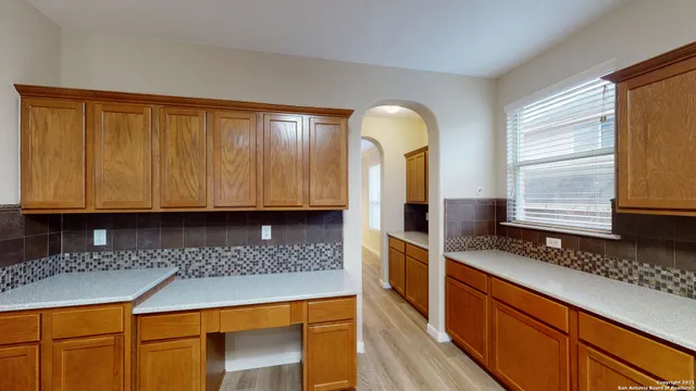 a kitchen with granite countertop a sink a stove and cabinets