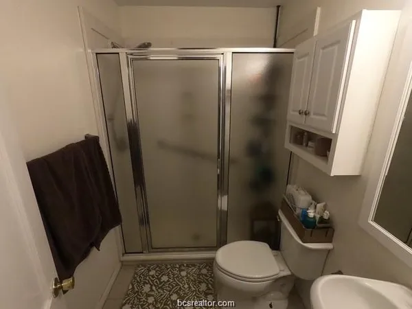 a bathroom with a toilet and a shower