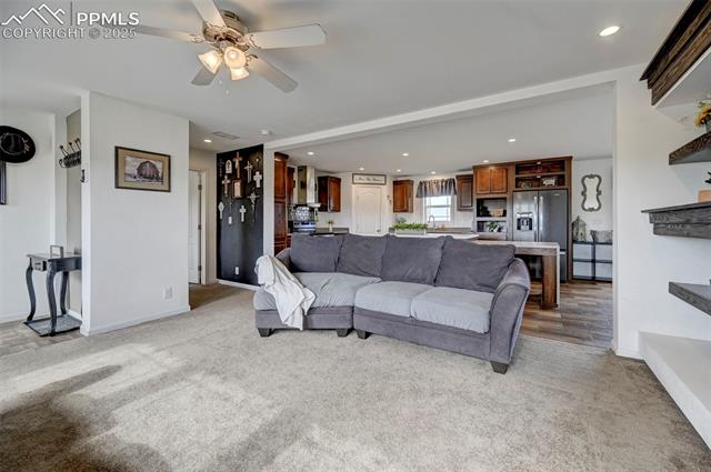 961 Buffalo Run Road Calhan, CO 80808 - Photo 39 of 45 Living room with ceiling fan and light carpet