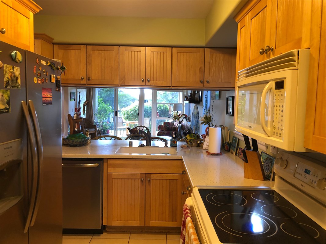 68-1745 Waikoloa Road, Unit J101 Waikoloa, HI 96738 - Photo 2 of 5 a kitchen with stainless steel appliances a sink a stove and a refrigerator