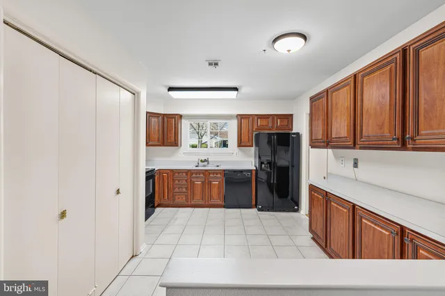 a large kitchen with stainless steel appliances granite countertop a refrigerator and a sink