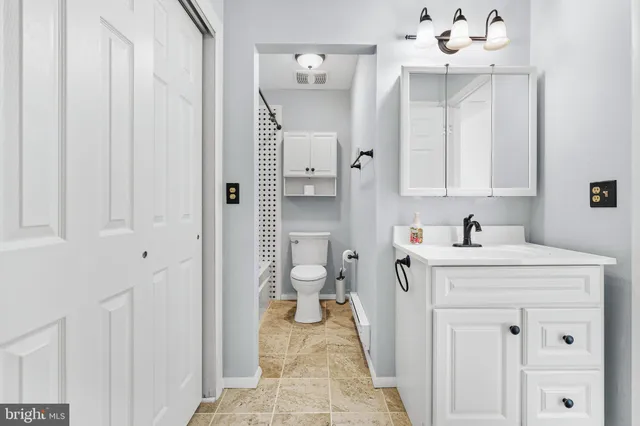 a bathroom with a sink vanity and a toilet