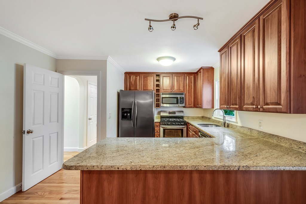 43 Kendall Road Newton, MA 02459 - Photo 7 of 22 a kitchen with stainless steel appliances granite countertop a sink a stove and a refrigerator