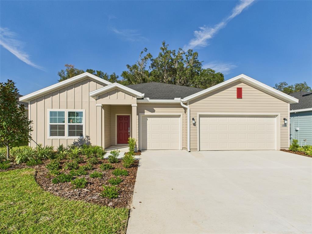 a view of a house with a yard and potted plants
