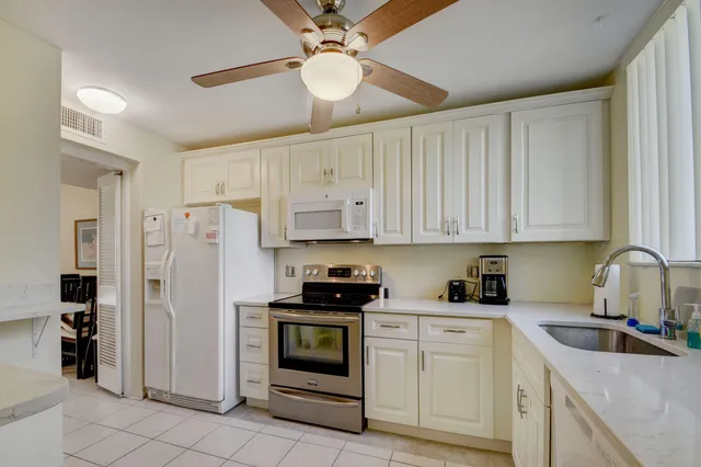a kitchen with stainless steel appliances granite countertop a refrigerator sink and cabinets