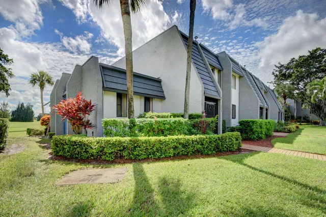 a view of a house with a big yard and potted plants