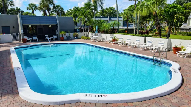 a view of a swimming pool with a patio and a yard