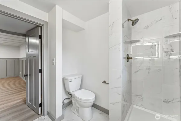a bathroom with a toilet and a shower