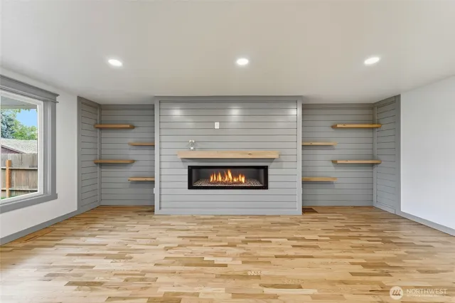 a view of an empty room with a fireplace and a window