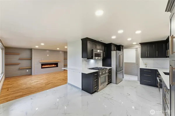 a large kitchen with stainless steel appliances kitchen island granite countertop a large counter top and oven