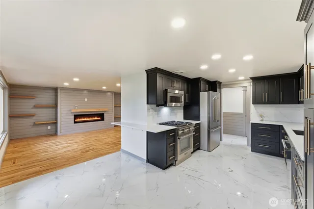a large kitchen with stainless steel appliances kitchen island granite countertop a large counter top and oven