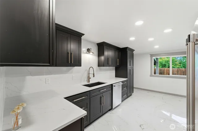 a kitchen with stainless steel appliances a sink stove and cabinets