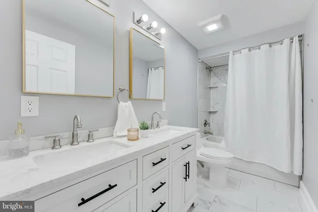 a bathroom with a double vanity sink toilet and shower