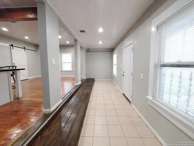 a hallway with wooden floor and chandelier