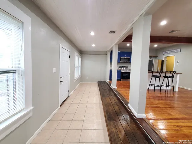 an empty room with wooden floor and window