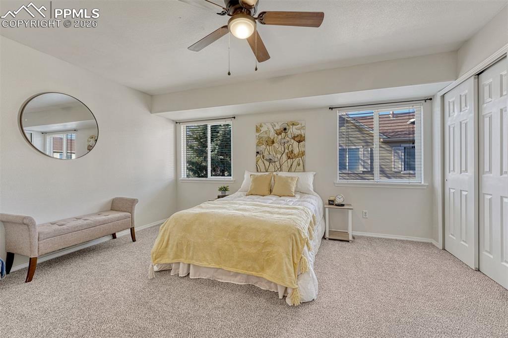 2580 Malpaso Point Colorado Springs, CO 80922 - Photo 10 of 23 a bedroom with a bed and a chandelier