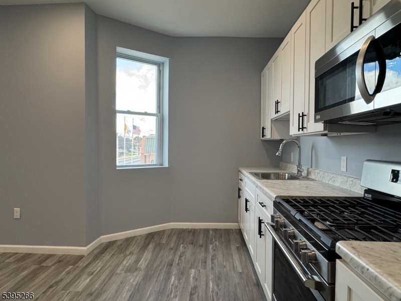 155 Clifton Avenue, Unit 3RR Newark, NJ 07104 - Photo 2 of 13 a kitchen with granite countertop a stove a sink and wooden floor