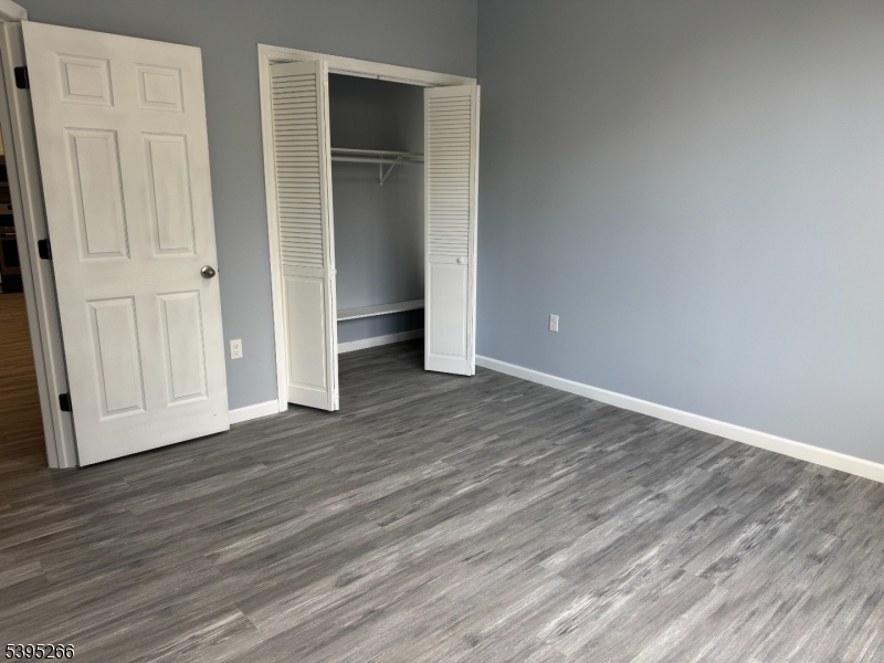 155 Clifton Avenue, Unit 3RR Newark, NJ 07104 - Photo 5 of 13 an empty room with wooden floor & closet area