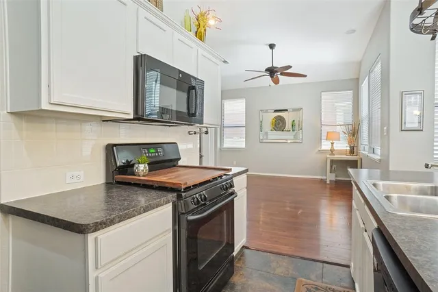 a kitchen with granite countertop stainless steel appliances a stove sink and microwave