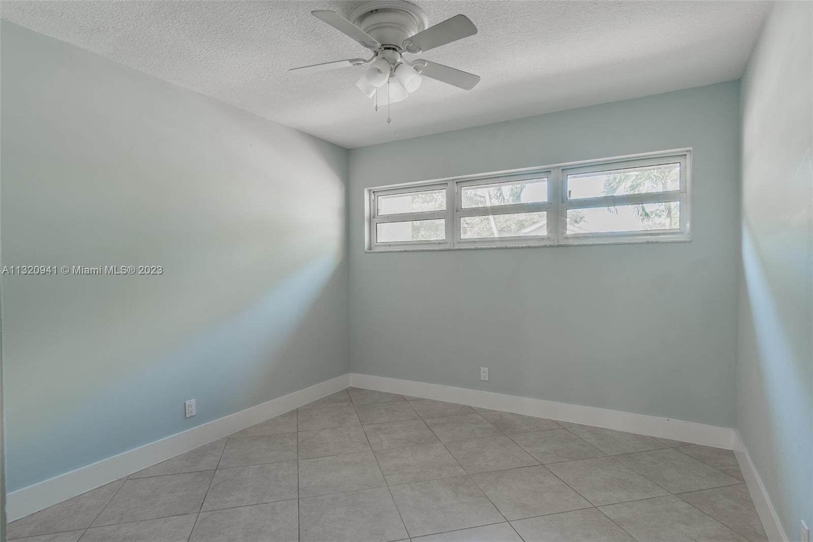 Jacaranda Plantation, FL 33324 - Photo 16 of 22 an empty room with a window and a ceiling fan