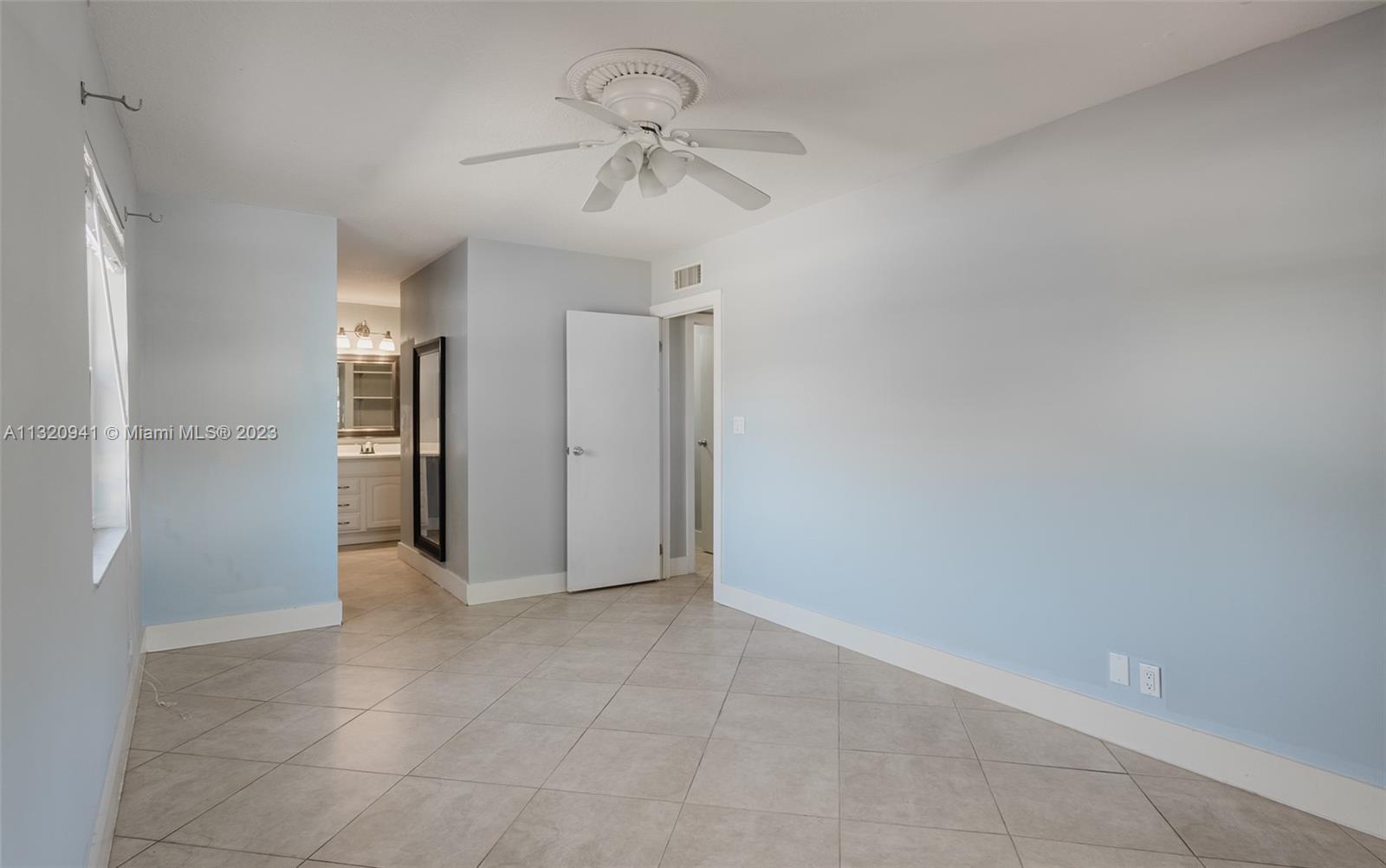 Jacaranda Plantation, FL 33324 - Photo 10 of 22 a view of a hallway with a chandelier fan and windows