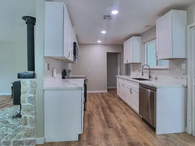 a kitchen with sink a microwave and cabinets