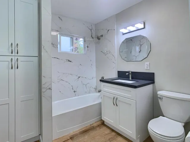 a bathroom with a toilet a sink and a mirror
