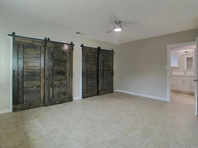 a bedroom with a bed dresser and a potted plant