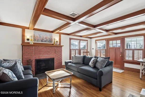 a living room with furniture a fireplace and wooden floor