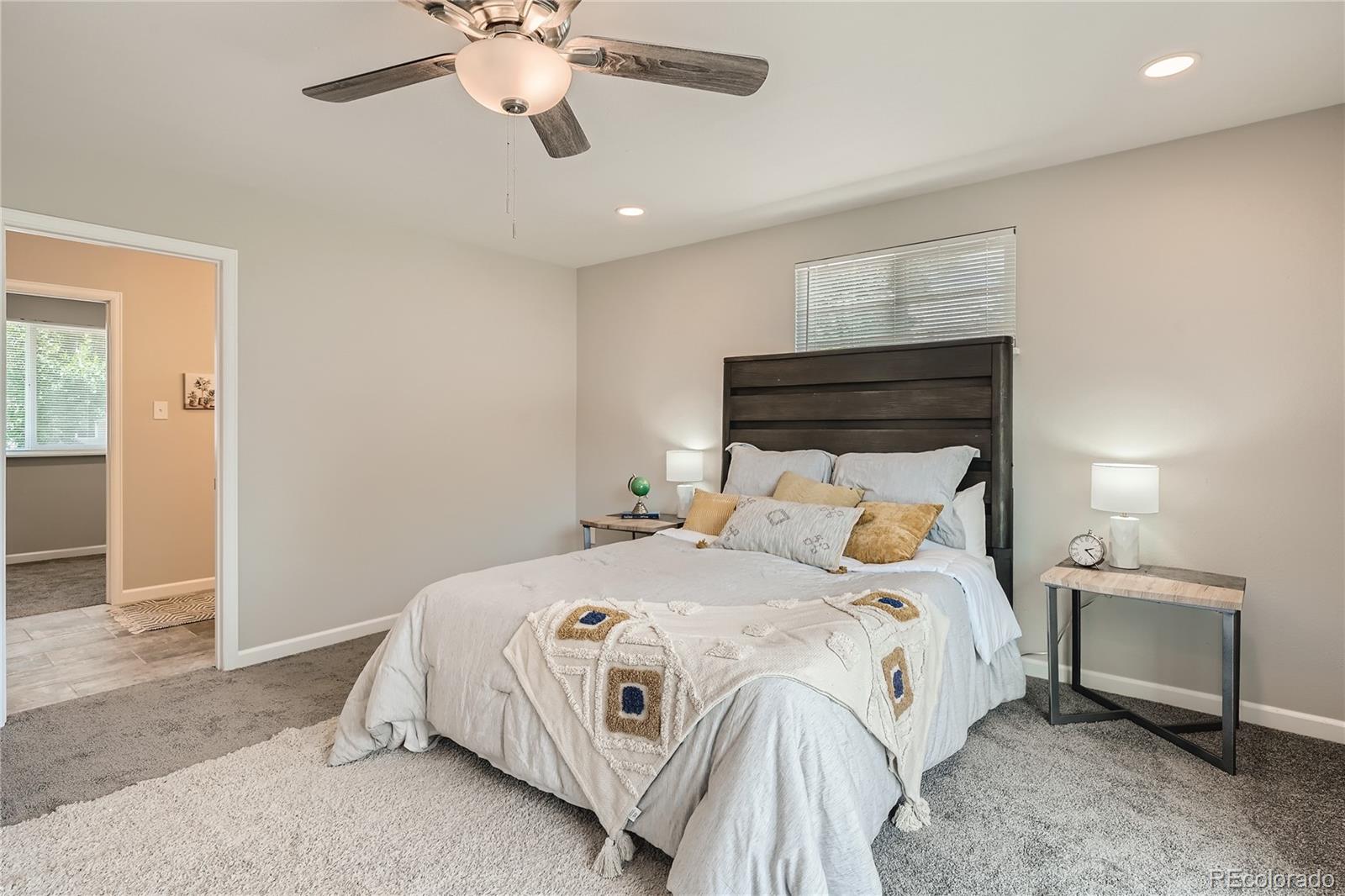 8506 Eaton Street Arvada, CO 80003 - Photo 14 of 28 a bedroom with a bed and a chandelier