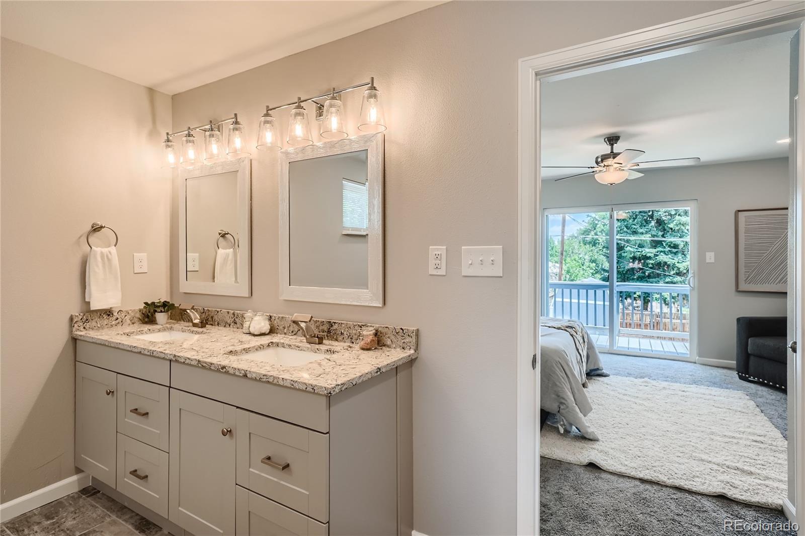 8506 Eaton Street Arvada, CO 80003 - Photo 15 of 28 a spacious bathroom with a double vanity sink and a mirror