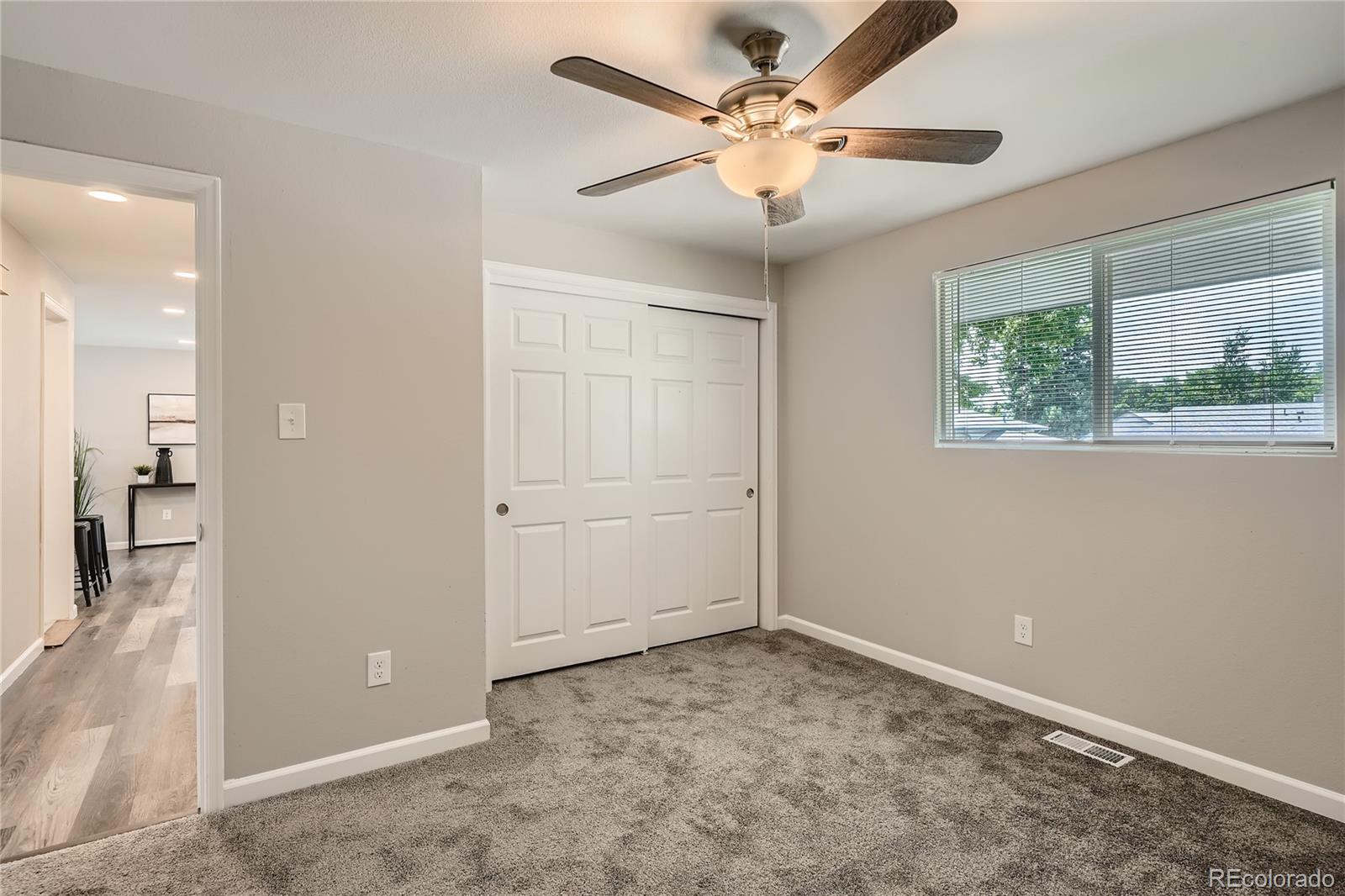 8506 Eaton Street Arvada, CO 80003 - Photo 17 of 28 en empty room with windows and ceiling fan