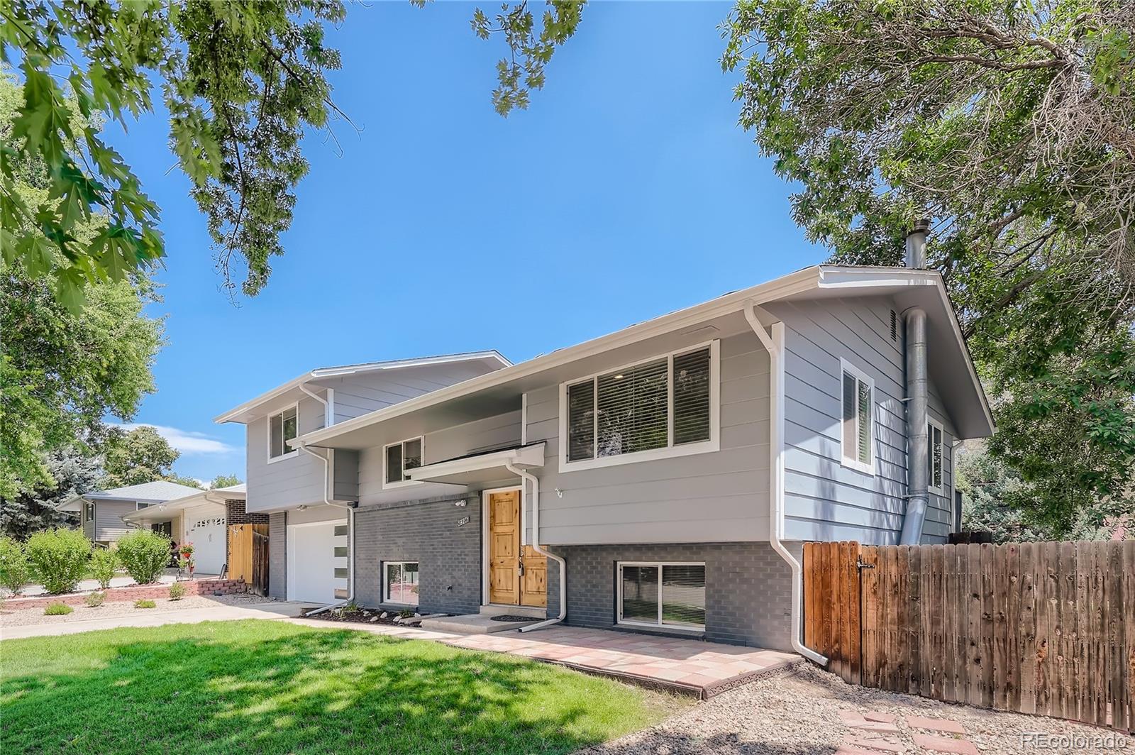 8506 Eaton Street Arvada, CO 80003 - Photo 2 of 28 a front view of a house with a garden and plants