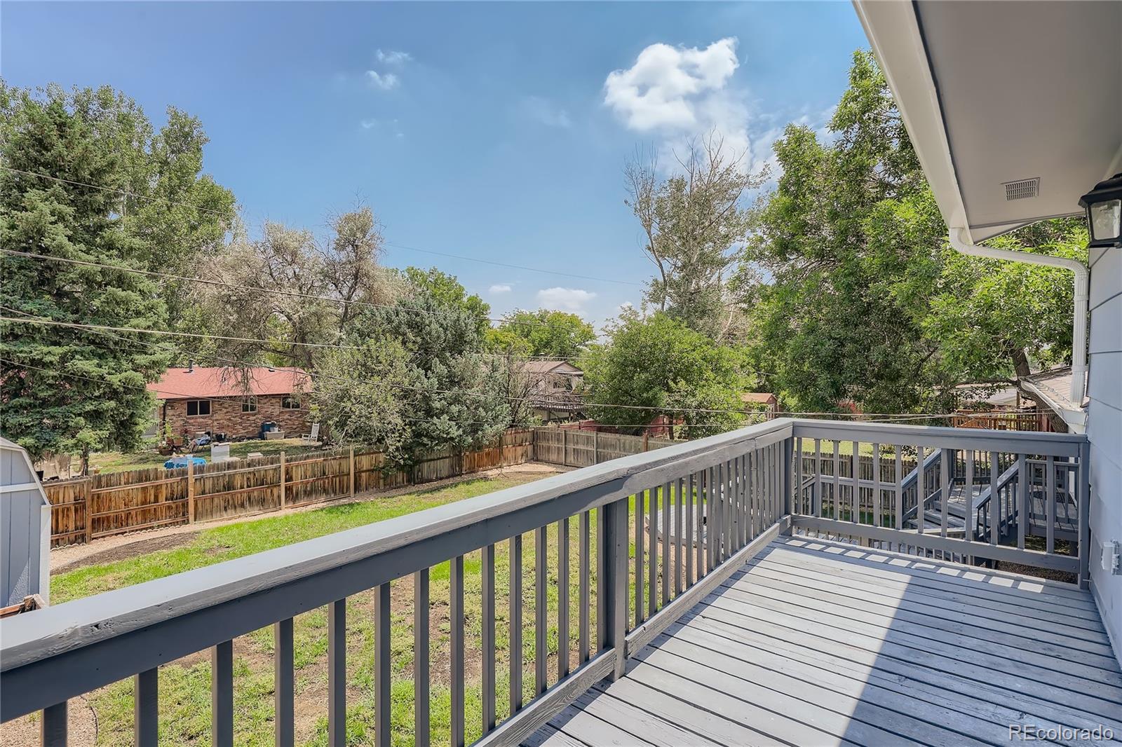 8506 Eaton Street Arvada, CO 80003 - Photo 24 of 28 a balcony with wooden floor and fence