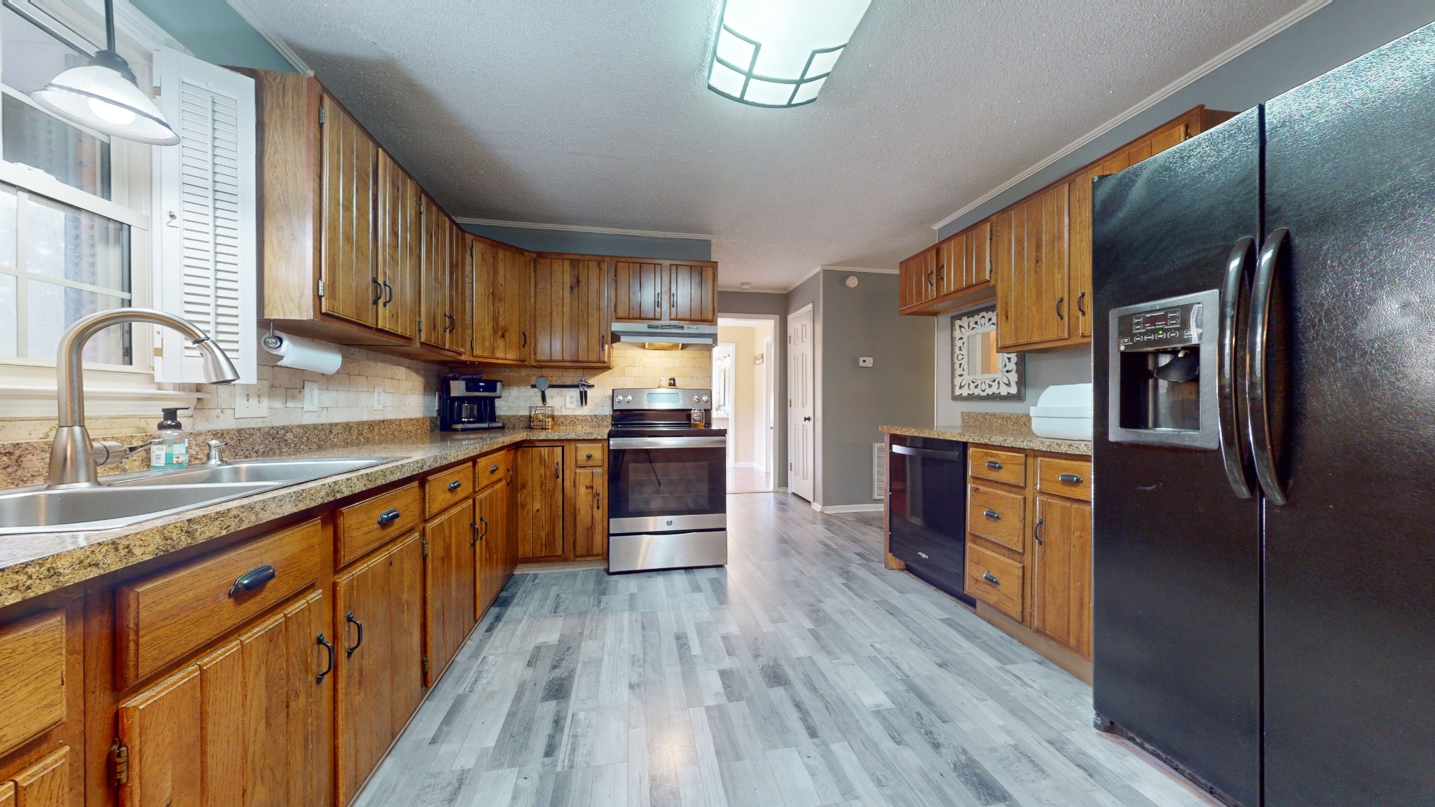 511 Limestone Road Elora, TN 37328 - Photo 19 of 55 a kitchen with stainless steel appliances granite countertop a refrigerator a sink dishwasher a stove and a dining table with wooden floor